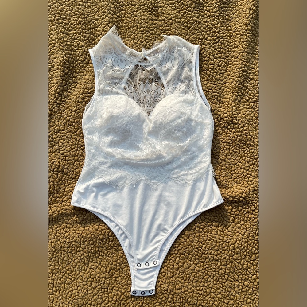 WHITE SLEEVELESS BODY SUIT WITH LACE. UNKNOWN BRAND. NEVER WORN. SIZE L